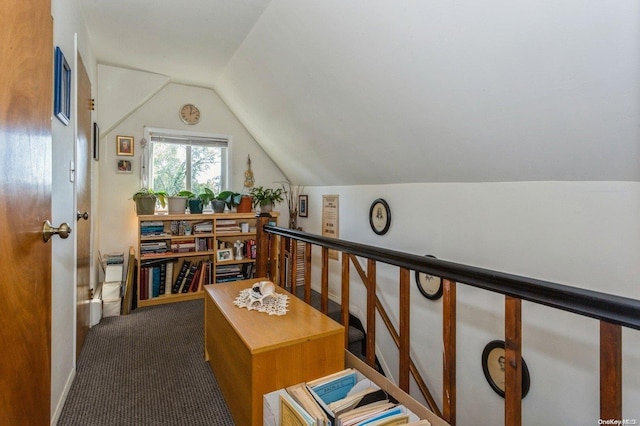 hall with dark carpet and lofted ceiling