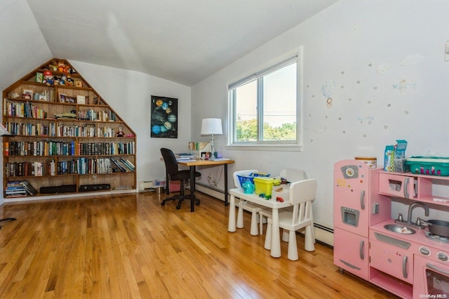 office area featuring a baseboard heating unit, light wood-type flooring, sink, and vaulted ceiling