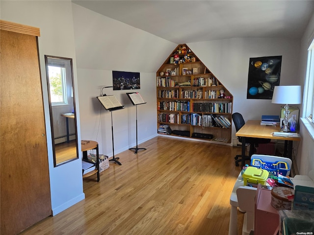 office space with hardwood / wood-style flooring, vaulted ceiling, and a baseboard radiator