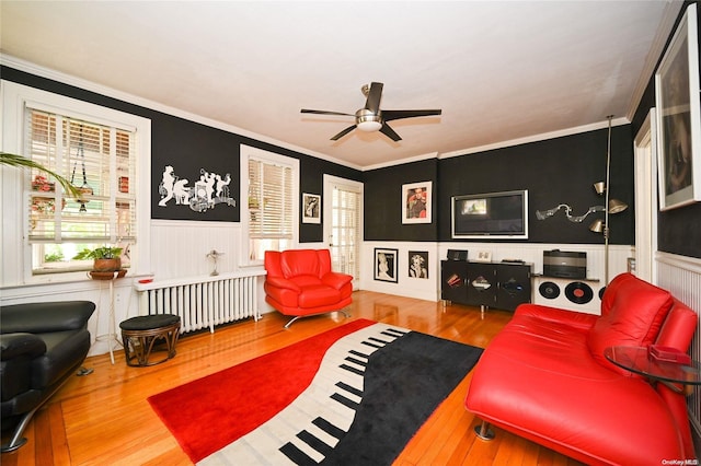 living room with wood-type flooring, radiator, and crown molding