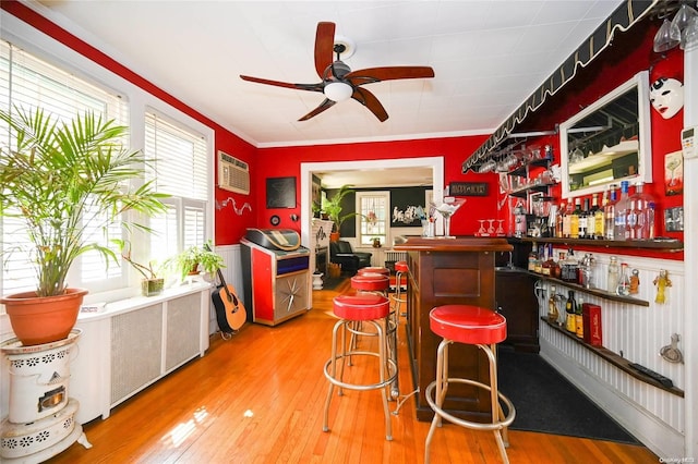 bar featuring hardwood / wood-style floors, ceiling fan, ornamental molding, and a wall mounted AC