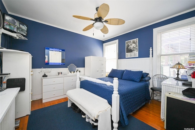 bedroom with dark hardwood / wood-style flooring, ceiling fan, and ornamental molding