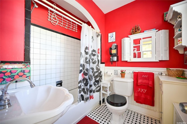 full bathroom featuring tile walls, sink, shower / bath combo, and toilet