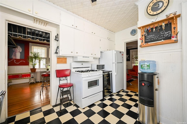 kitchen featuring white cabinets, white appliances, and dark wood-type flooring