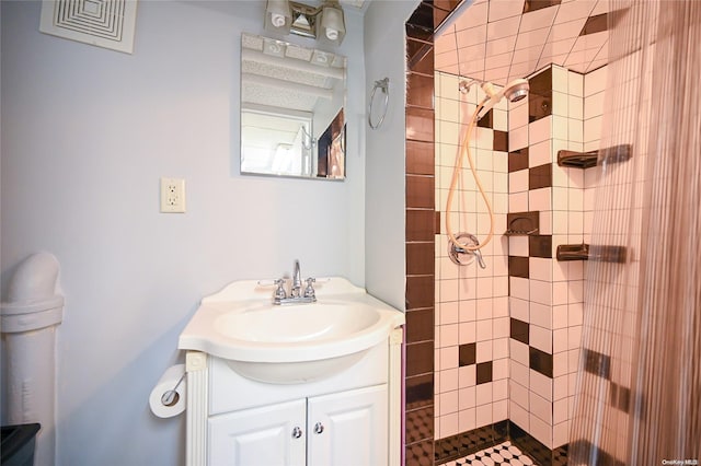 bathroom with vanity and tiled shower