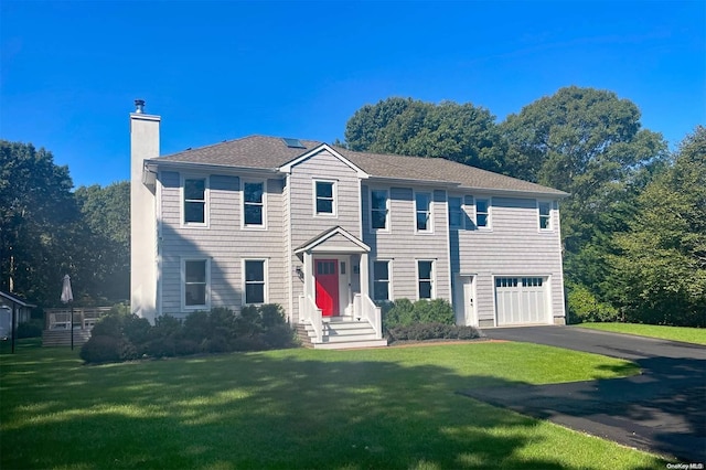 colonial home featuring a garage and a front yard