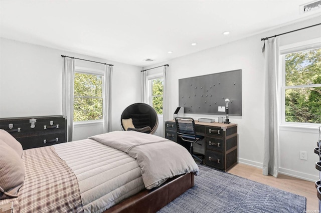 bedroom featuring multiple windows and light wood-type flooring