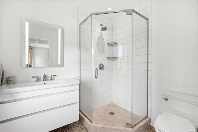 bathroom featuring toilet, vanity, tile patterned floors, and a shower with door