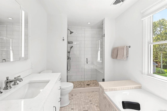 bathroom with tile patterned flooring, plenty of natural light, toilet, and a shower with shower door