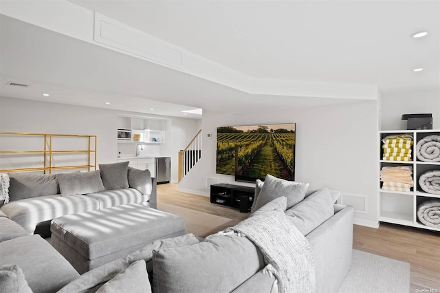 living room with sink and light hardwood / wood-style flooring