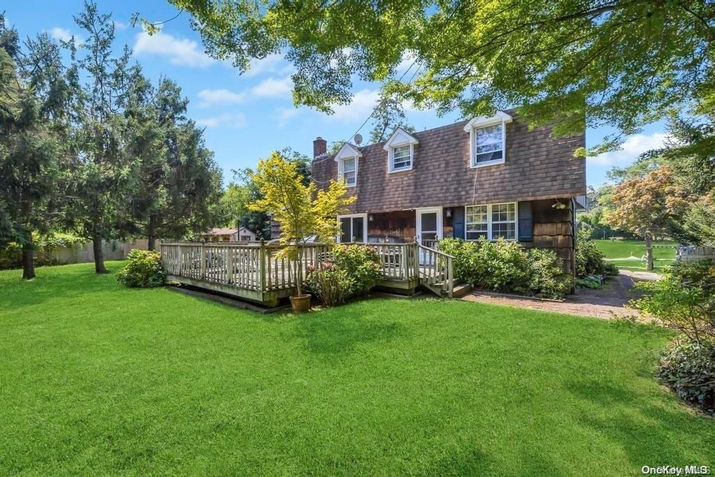 back of house featuring a wooden deck and a lawn