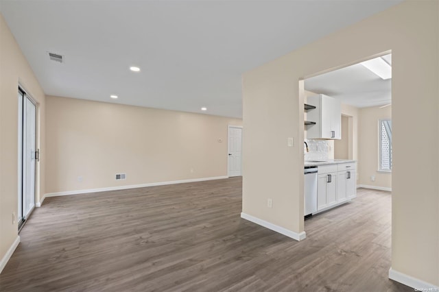 unfurnished living room featuring sink and wood-type flooring