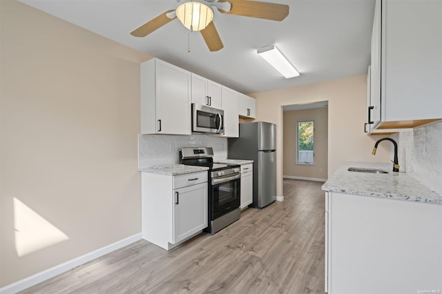 kitchen featuring white cabinets, decorative backsplash, light hardwood / wood-style floors, and appliances with stainless steel finishes