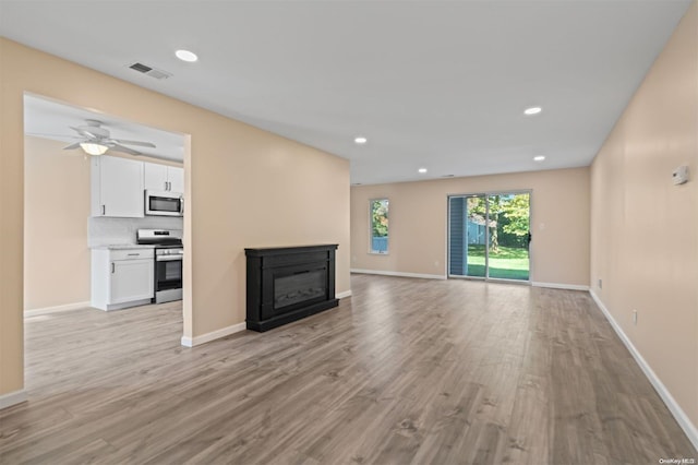 unfurnished living room featuring ceiling fan and light hardwood / wood-style flooring