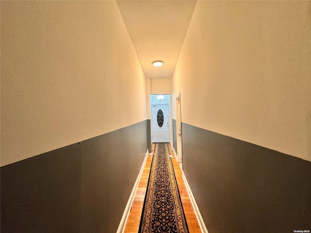 hall with wood-type flooring and washer / dryer