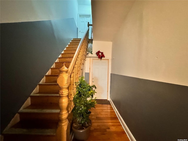 stairs with wood finished floors and baseboards