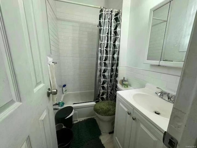 bathroom with toilet, tile walls, shower / tub combo with curtain, and vanity