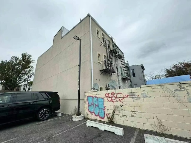 view of side of home featuring uncovered parking and stucco siding