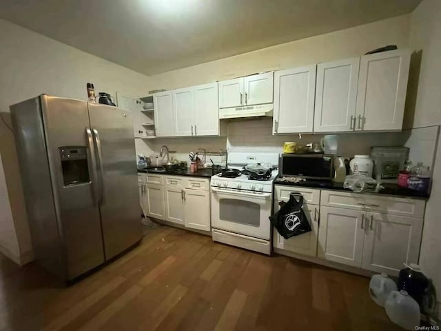 kitchen with dark countertops, under cabinet range hood, white cabinets, and stainless steel appliances