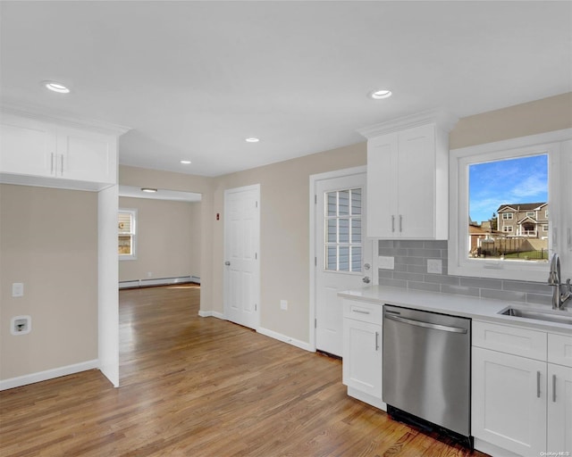 kitchen with sink, stainless steel dishwasher, a baseboard heating unit, white cabinets, and light wood-type flooring