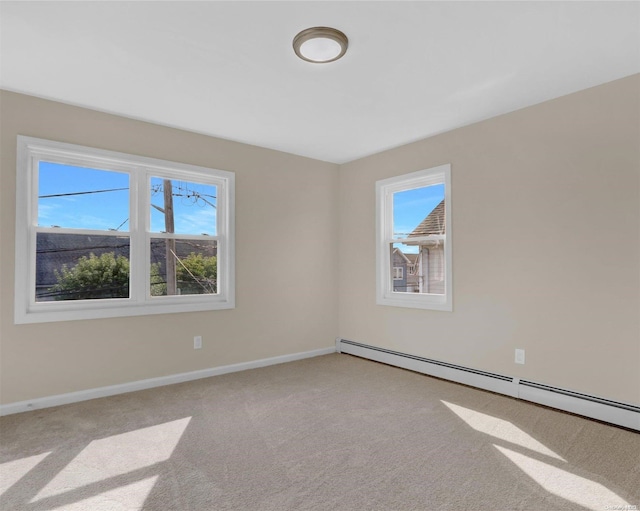 empty room featuring light colored carpet and a baseboard heating unit