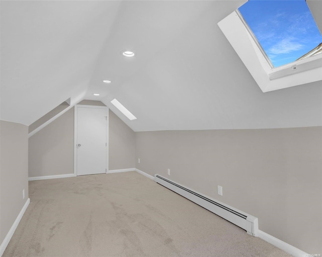 bonus room featuring vaulted ceiling with skylight, light colored carpet, and a baseboard heating unit