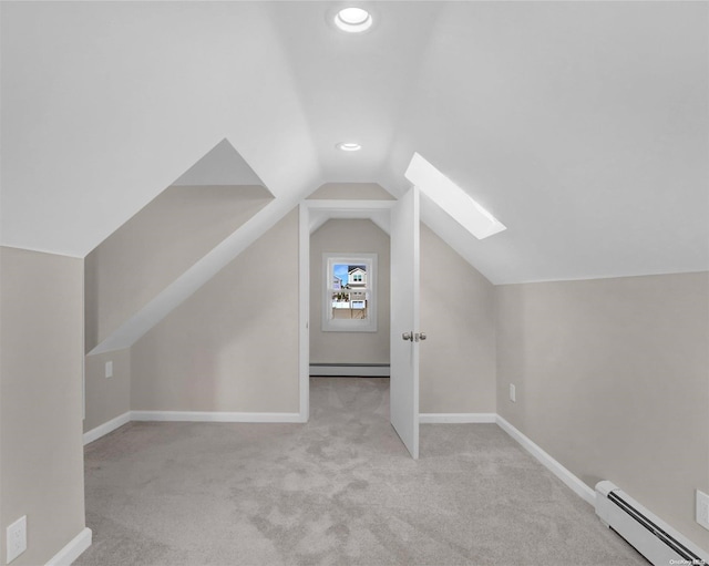 additional living space featuring light carpet, lofted ceiling with skylight, and baseboard heating