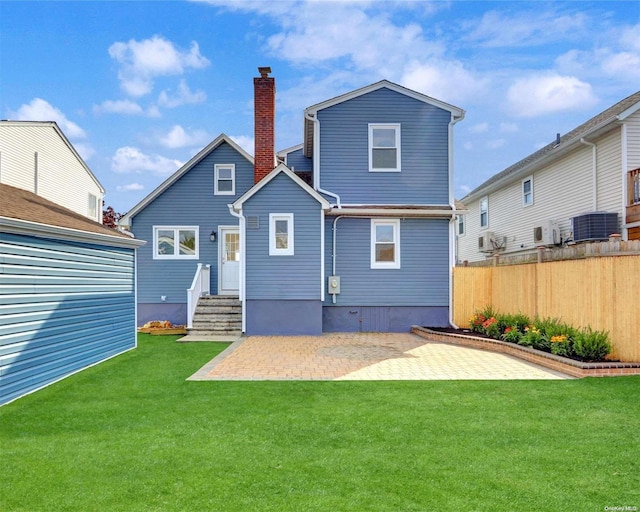 rear view of property featuring a lawn and a patio area