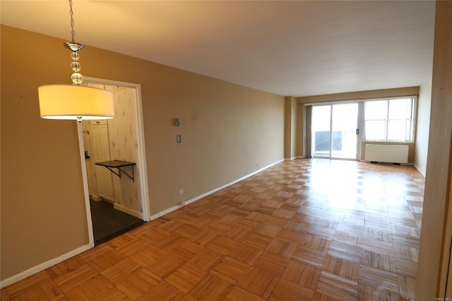 spare room featuring radiator heating unit and light parquet flooring