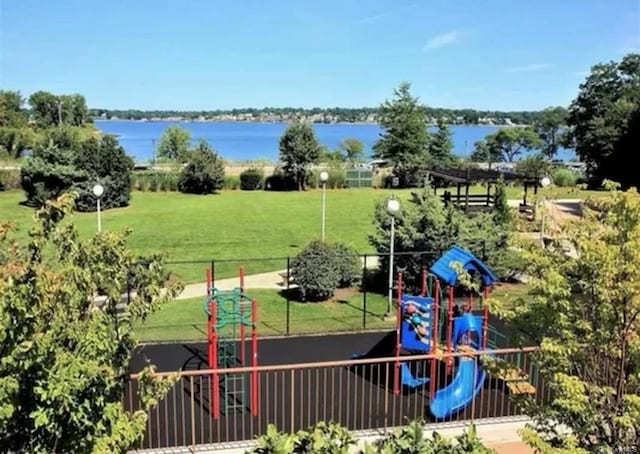 view of jungle gym featuring a lawn and a water view