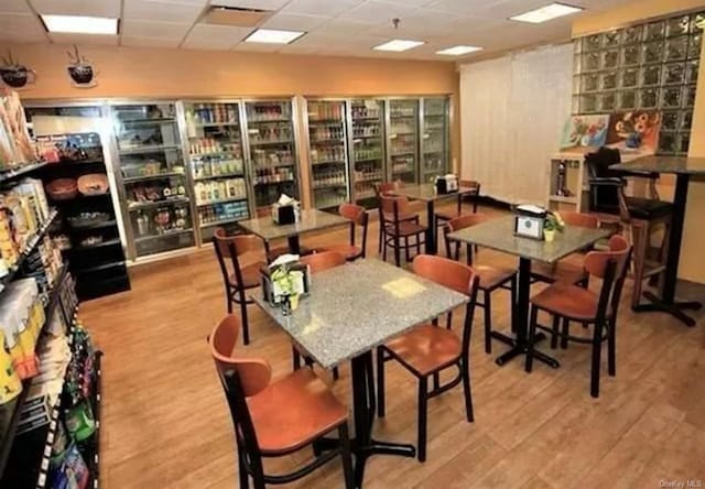 dining area featuring a drop ceiling and light wood-type flooring