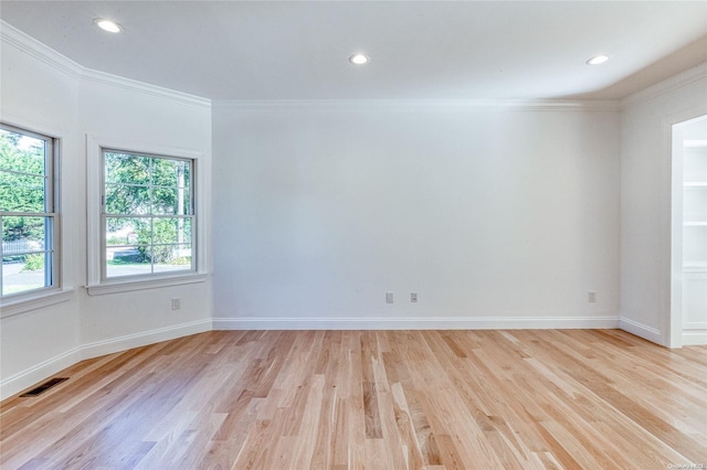 empty room featuring light hardwood / wood-style floors and ornamental molding