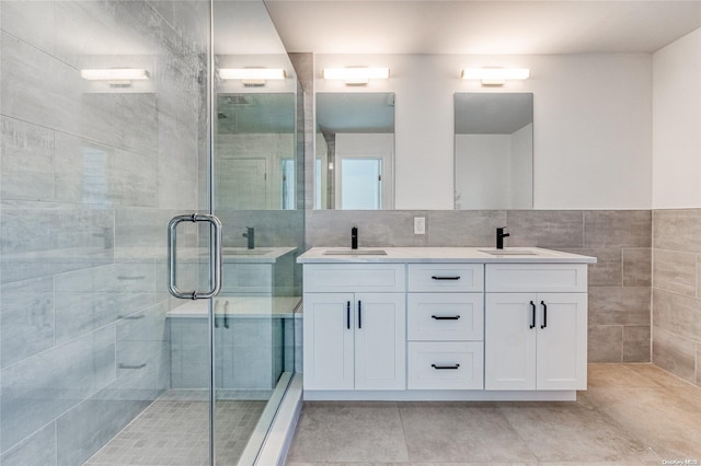 bathroom featuring tile patterned floors, vanity, an enclosed shower, and tile walls