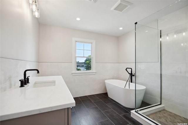 bathroom with vanity, tile walls, and independent shower and bath