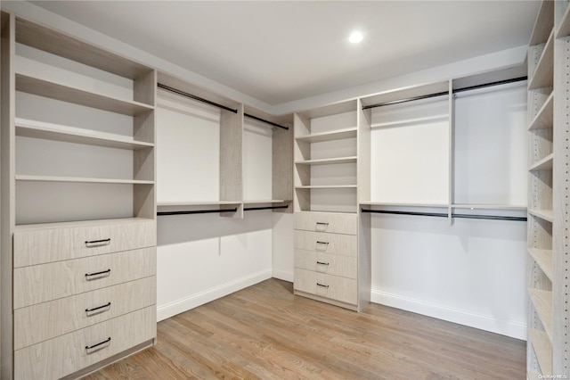 walk in closet with light hardwood / wood-style floors