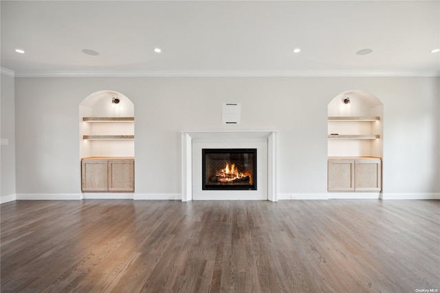 80 Ocean Ave, Massapequa, NY 11758 - unfurnished living room featuring baseboards, a glass covered fireplace, built in shelves, wood finished floors, and crown molding