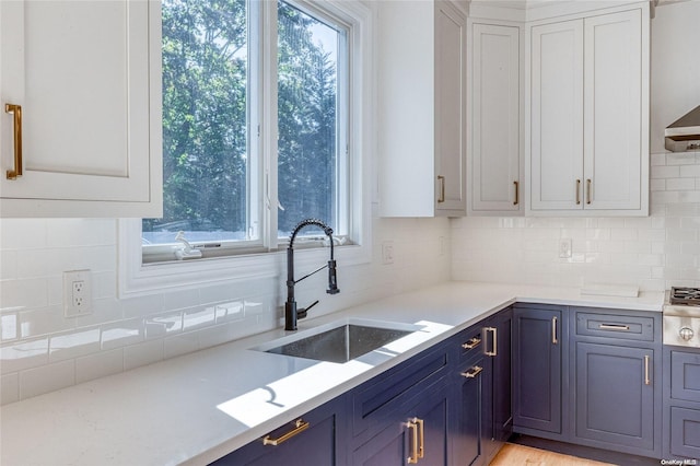 80 Ocean Ave, Massapequa, NY 11758 - kitchen featuring backsplash, stainless steel gas stovetop, white cabinetry, and a sink