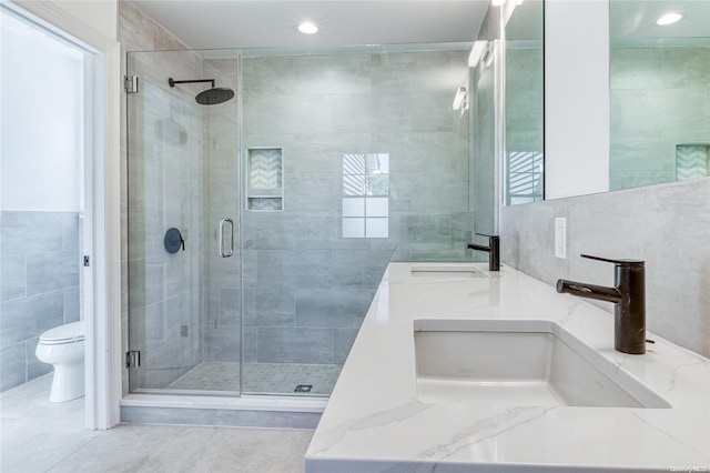 80 Ocean Ave, Massapequa, NY 11758 - full bathroom featuring tile walls, a sink, a shower stall, and toilet