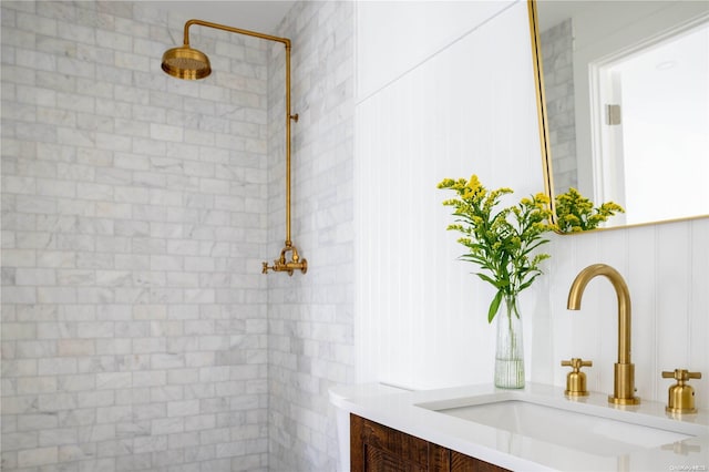 bathroom with tiled shower and vanity