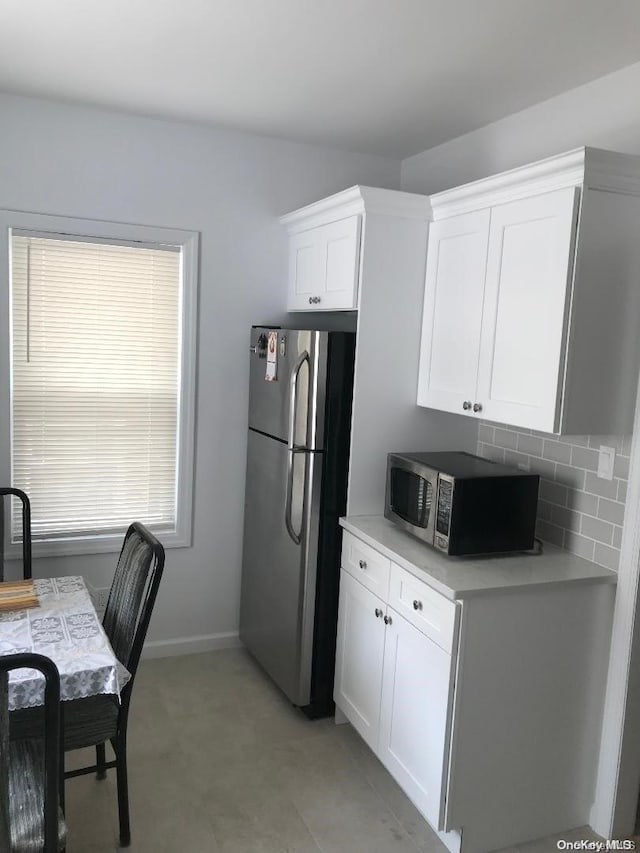 kitchen featuring white cabinets, appliances with stainless steel finishes, and tasteful backsplash