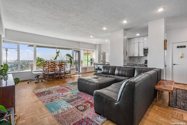 living room featuring a textured ceiling and light parquet floors