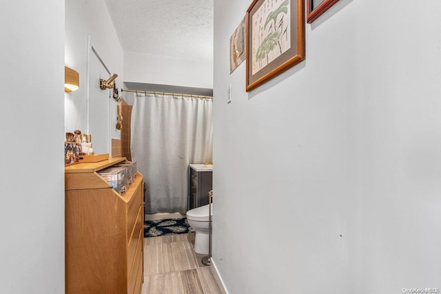 166-25 Powells Cove Blvd Unit 21G, Beechhurst, NY 11357 - full bath with a textured ceiling, toilet, curtained shower, and wood finished floors