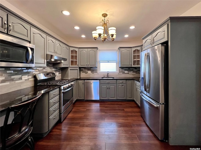 kitchen with appliances with stainless steel finishes, dark hardwood / wood-style flooring, sink, a chandelier, and gray cabinets