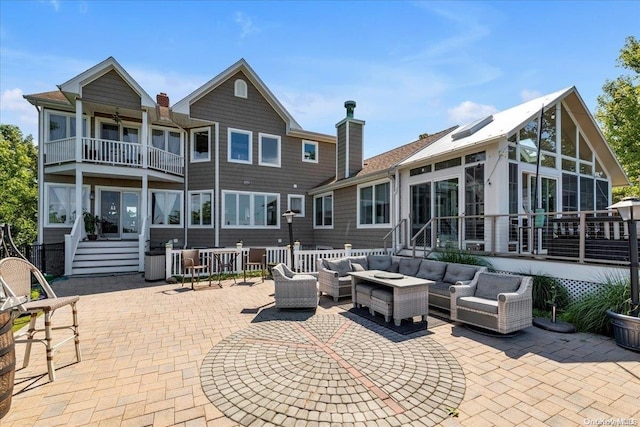 back of house featuring an outdoor living space and a patio area