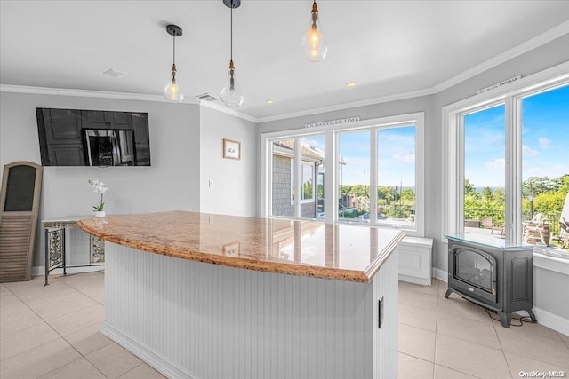 kitchen featuring light stone counters, white cabinetry, hanging light fixtures, and a wealth of natural light