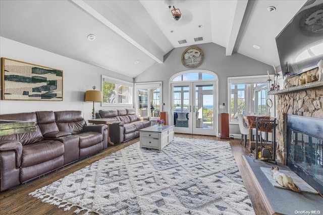 living room featuring a fireplace, lofted ceiling with beams, dark wood-type flooring, and french doors