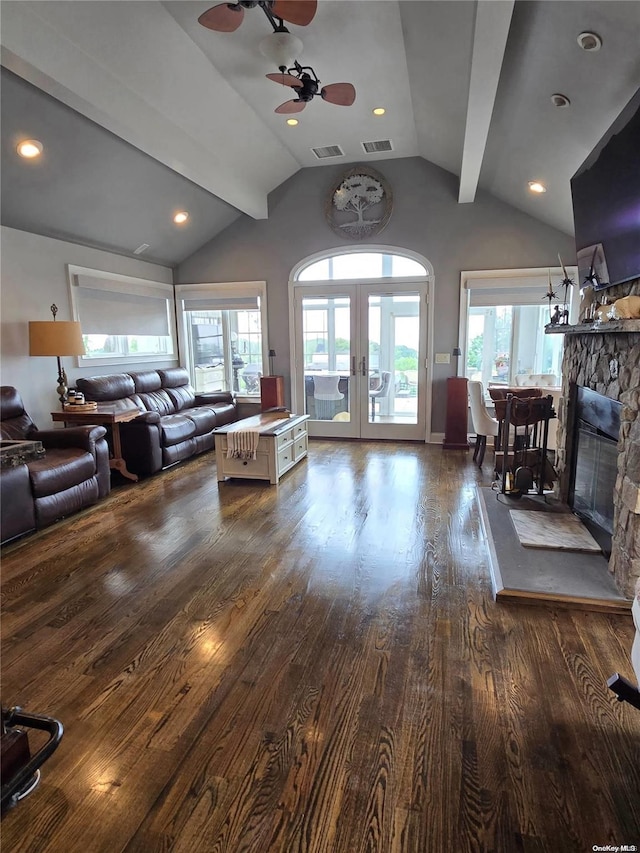 living room with lofted ceiling with beams, a wealth of natural light, and dark wood-type flooring