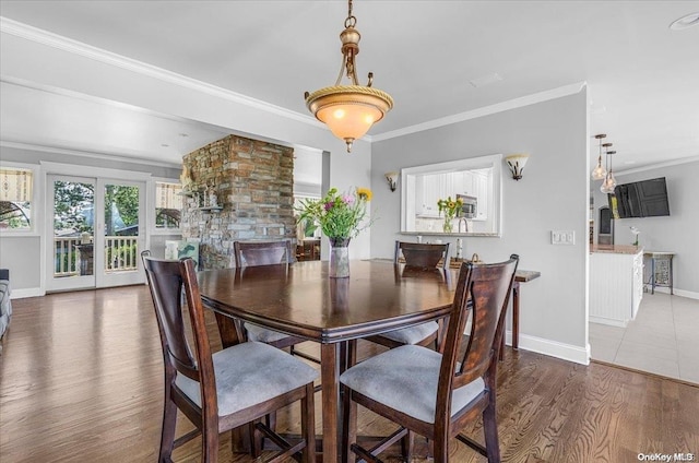 dining area with crown molding and dark wood-type flooring