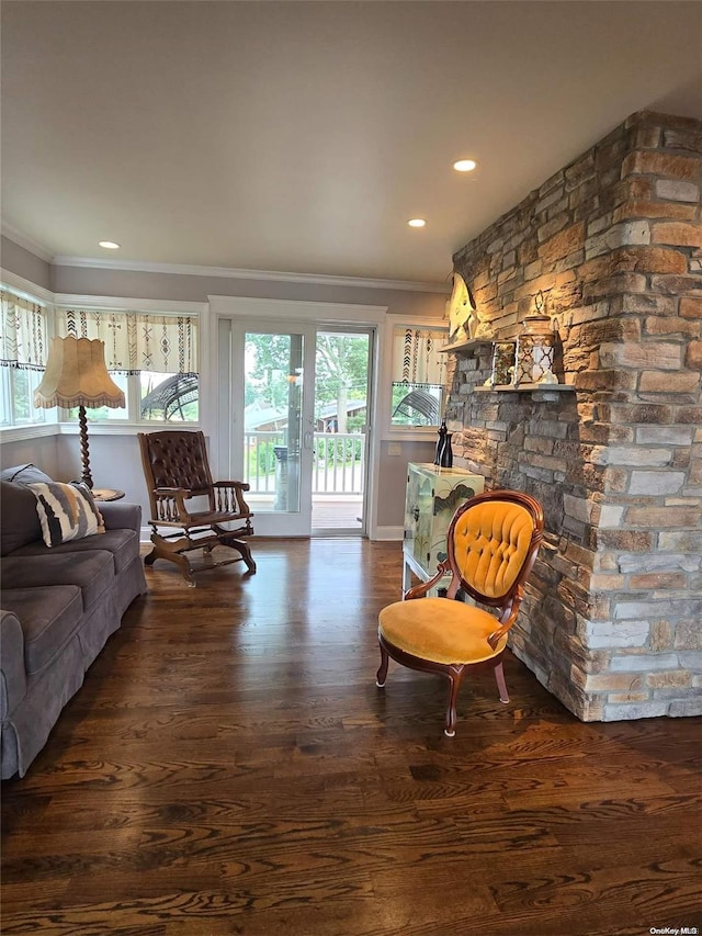 living room featuring dark hardwood / wood-style flooring, a wealth of natural light, and ornamental molding