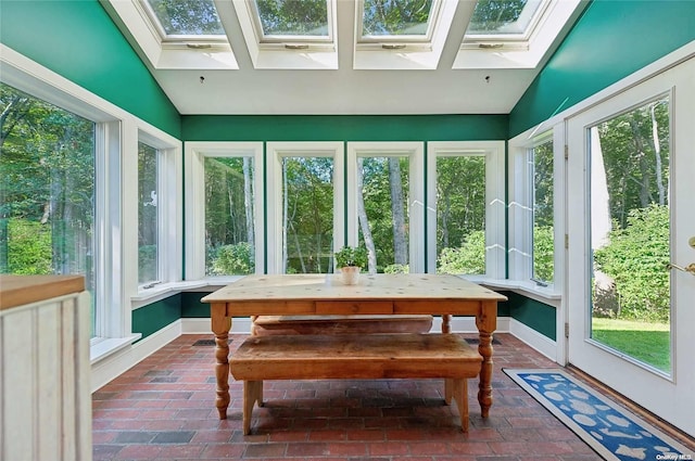 156 Ram Island Dr, Shelter Island, NY 11964 - sunroom featuring a skylight, plenty of natural light, brick flooring, and vaulted ceiling